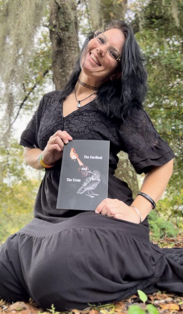 Image of author D.R. Austin holding a book titled 'The Cardinal and The Crow'